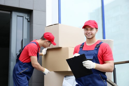 Local movers carrying household items through a central London apartment building